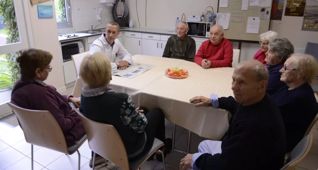 Table ronde de personnes âgées avec un soignant
