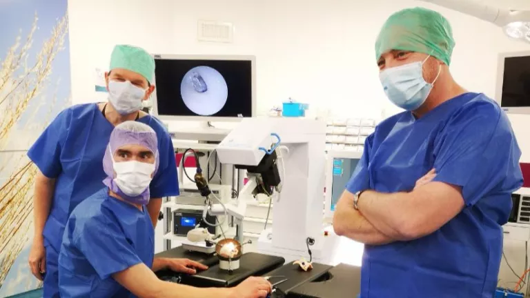 Trois chirurgiens devant un robot