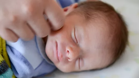 nouveau né souriant dans son sommeil