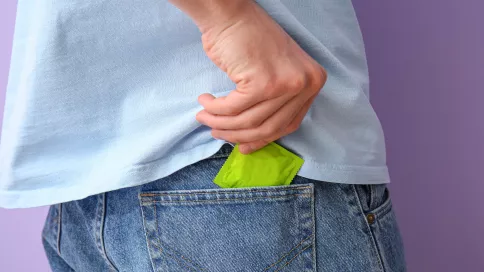 homme sort un préservatif de sa poche